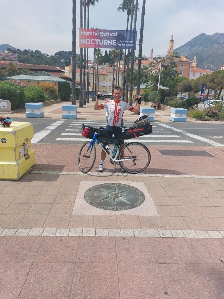 Photo souvenir du cycliste à l'arrivée de la route des Grandes Alpes - Menton